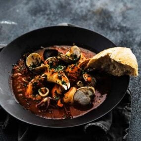 shellfish cooked in a tomato herb broth and served with bread