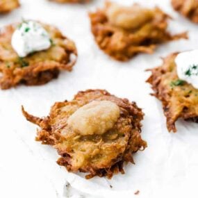 potato latke on a parchment paper with apple sauce on top