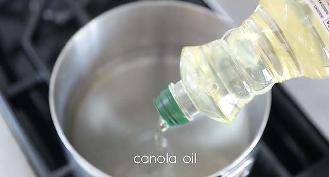 adding oil to a pot