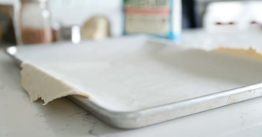 rolled out pie dough on a sheet tray