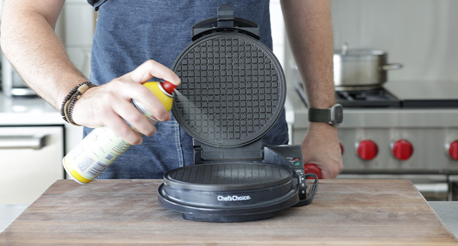 spraying a waffle iron