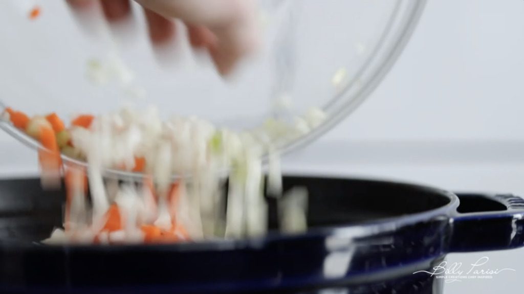 adding vegetables to the soup pot