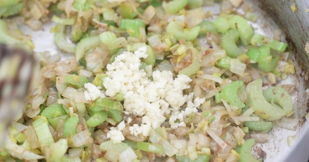 adding garlic to celery and onions