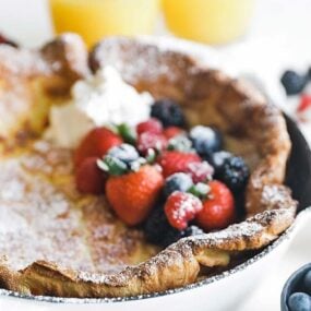 dutch baby in a skillet with fresh berries