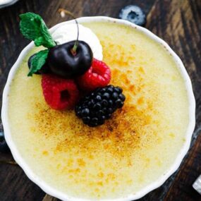 creme brulee dish with toasted top, fresh berries and whipped cream