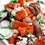 watermelon feta salad with steak on a platter