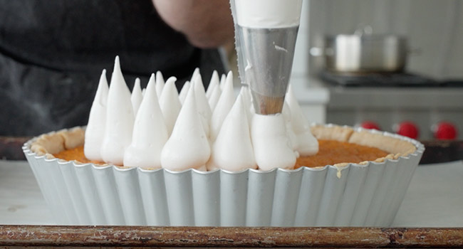 decorating a sweet potato pie with meringue