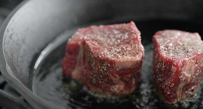 filet mignon in a pan of oil