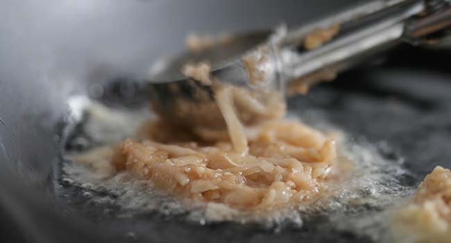 flattening out a latke in oil