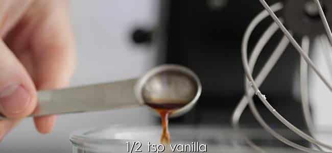 pouring vanilla extract into a stand mixer