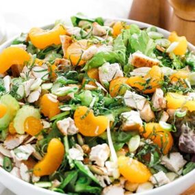 Mandarin orange salad in a bowl with herbs and chicken