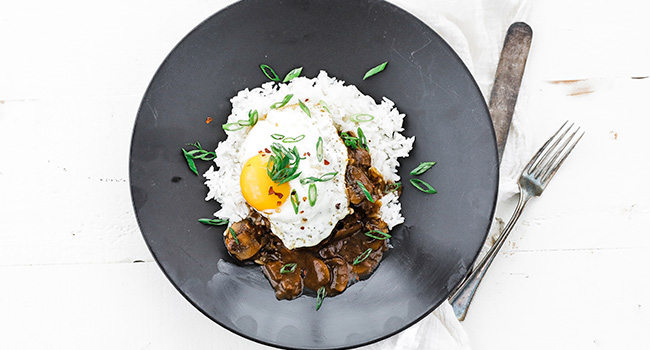 fried egg on a burger patty with mushroom gravy and rice