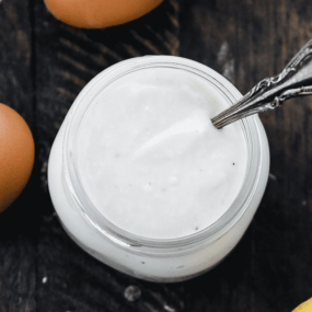 glass of caesar dressing with a spoon