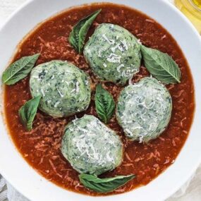 bowl of tomato sauce with spinach gnudi