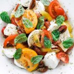 caprese salad on a plate with herbs