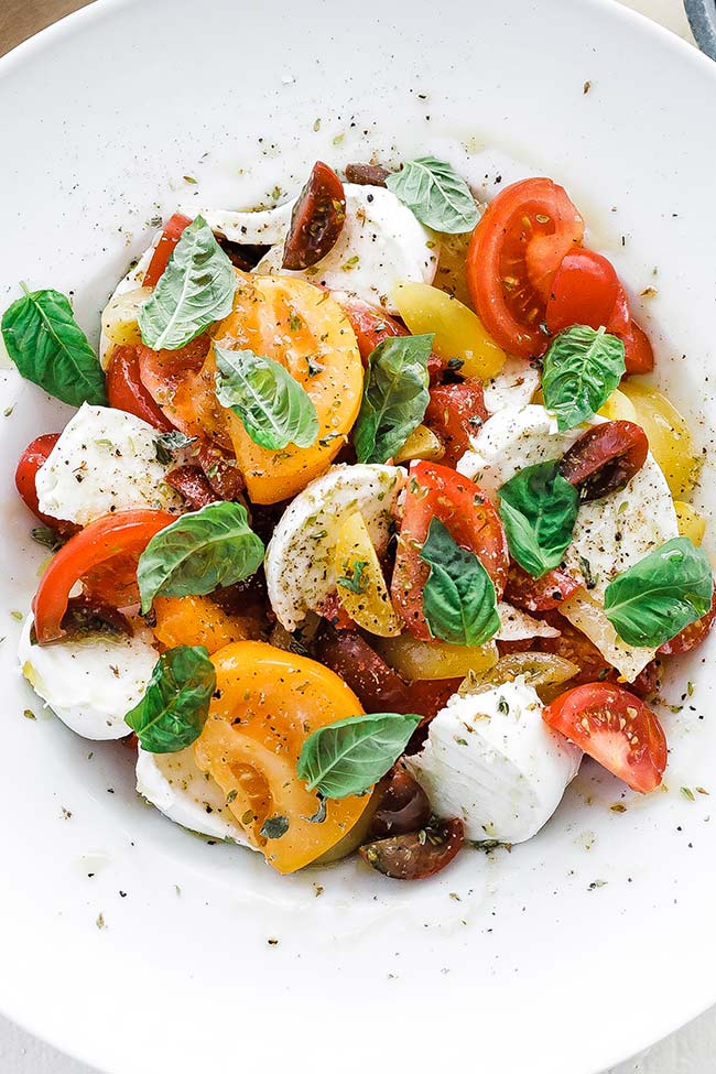 caprese salad on a plate with herbs