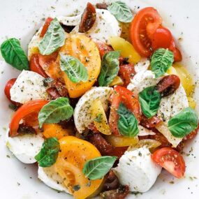 caprese salad on a plate with herbs