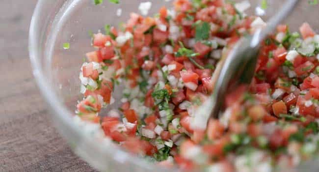 making a pico de gallo salsa in a bowl