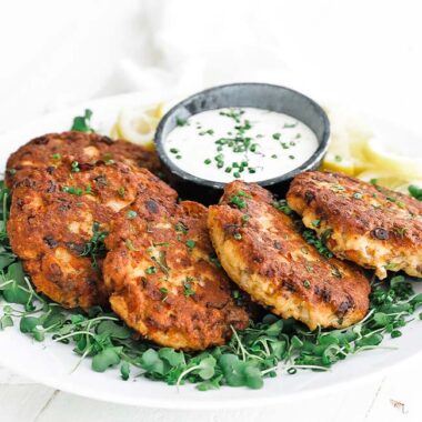 salmon patties on a plate of greens