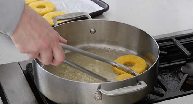 adding pineapple to a pan