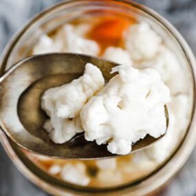 pickled cauliflower on a spoon and in a jar