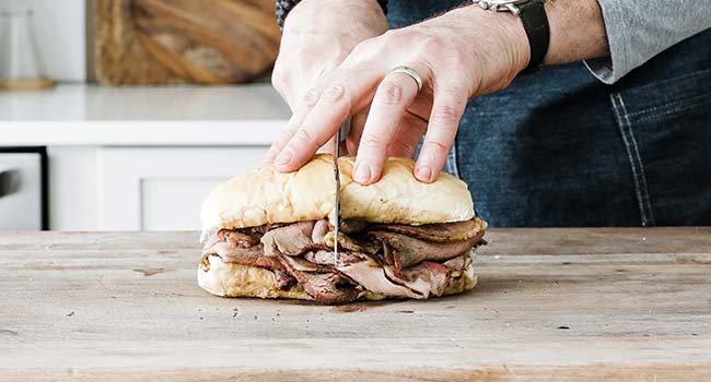 slicing a french dip sndwich