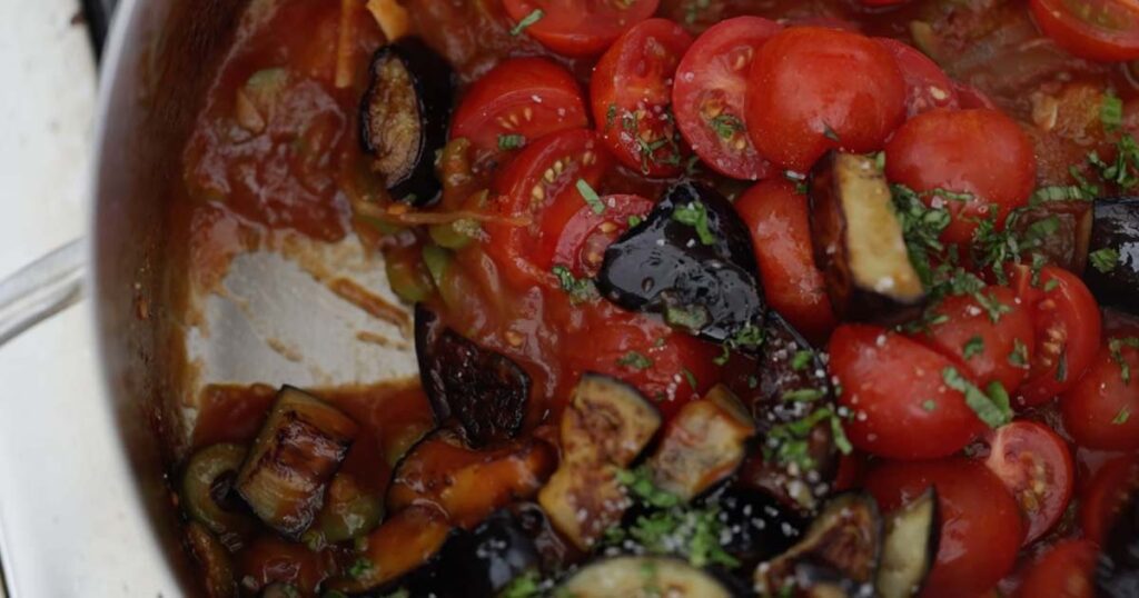 stirring in tomatoes to make caponata