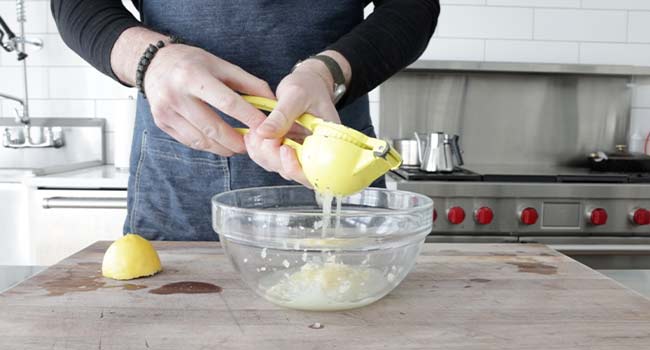 squeezing lemon juice into a bowl