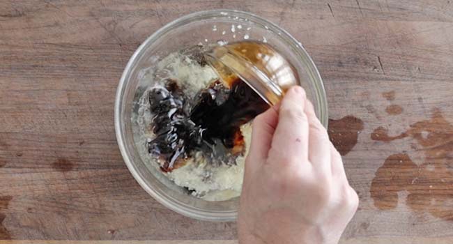 adding soy sauce to a bowl