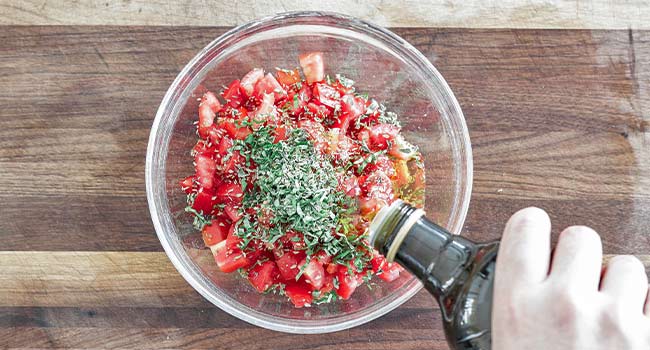 adding oil to bruschetta