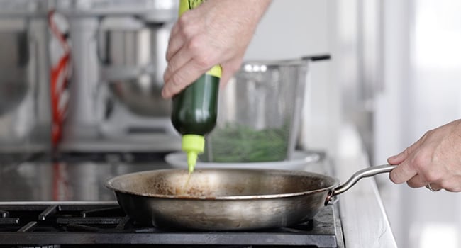 adding oil to a pan