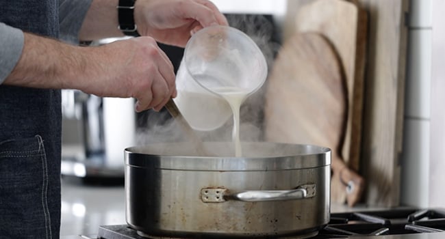 pouring flour and water into a pot