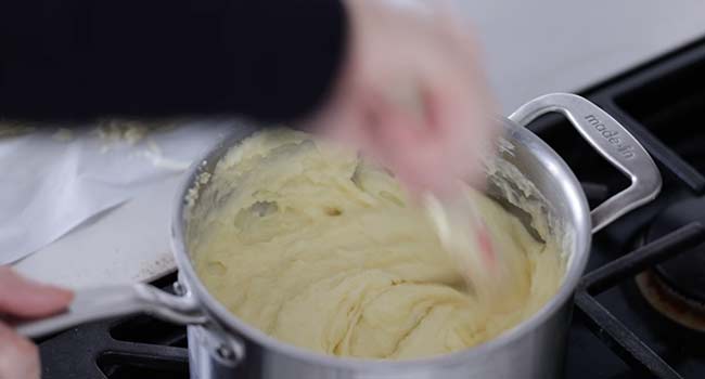 mixing potatoes with cream and cheese