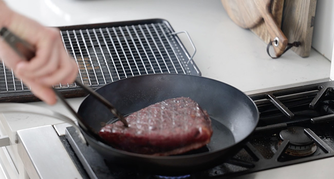 cooking a steak in a pan