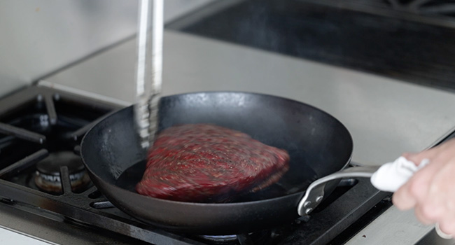 moving a picanha around in a pan