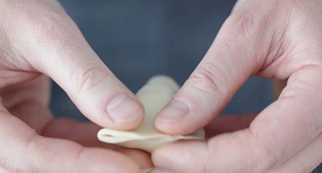 folding a dough round to make a crescent