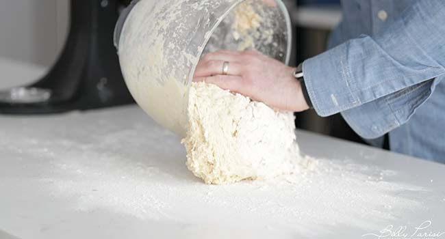 adding dough to a countertop