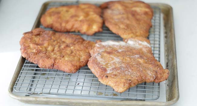 resting pork schnitzel on a rack