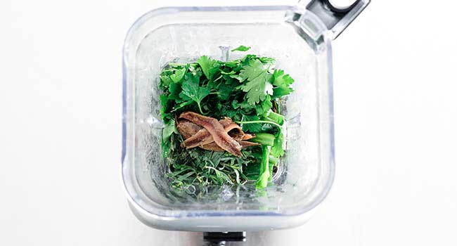 anchoives and herbs in a blender