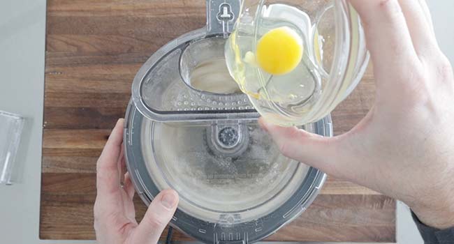 adding an egg to a food processor