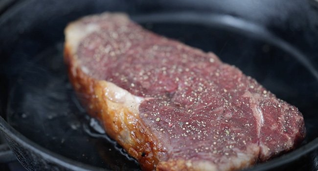 searing a steak in a pan