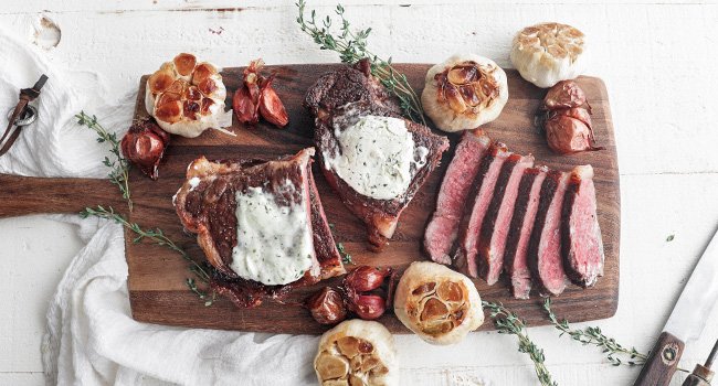 sliced steak on a cutting board with garlic