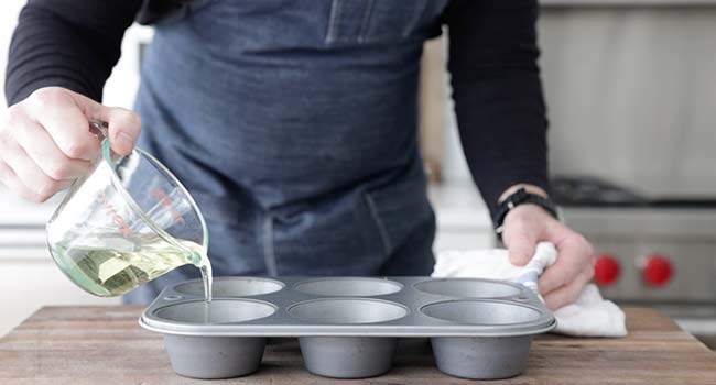 adding oil to a muffin tin