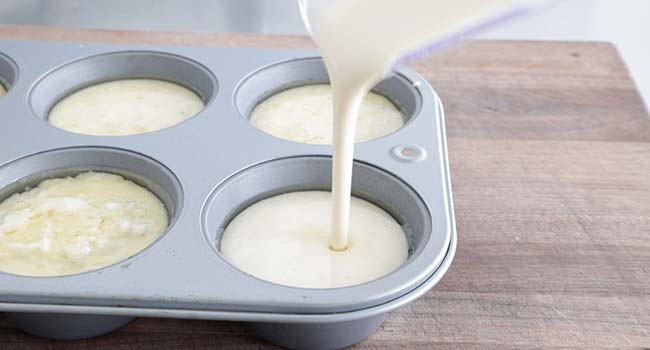 adding yorkshire pudding to a hot muffin tin