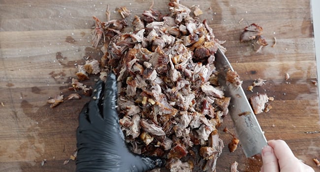 mixing carnitas with lime and salt