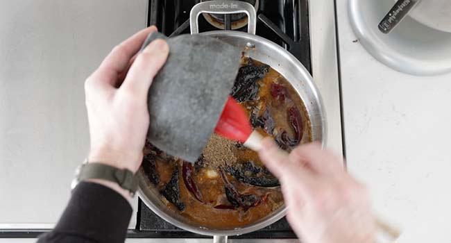 adding spices to chilis