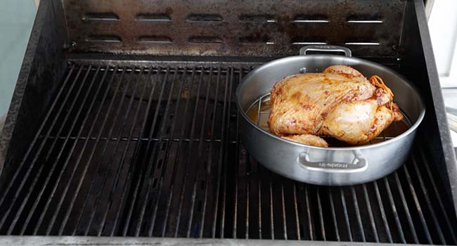 roasting a chicken on a grill