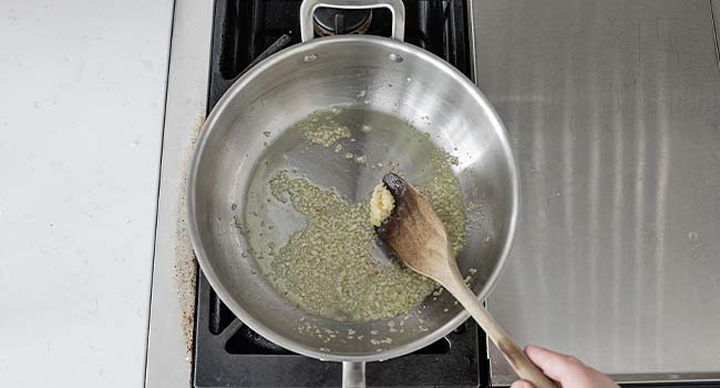 stirring garlic into a pan