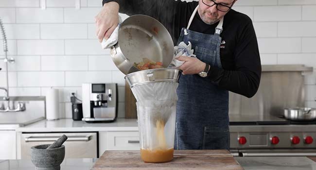 straining chicken stock