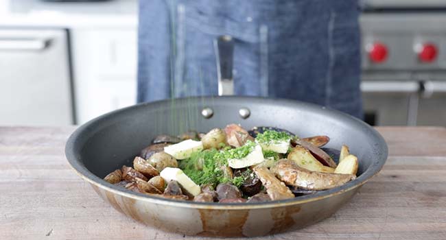 adding butter and herbs to fingerling potatoes